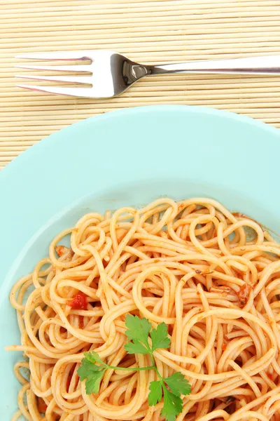 Italian spaghetti in plate on bamboo mat close-up — Stock Photo, Image