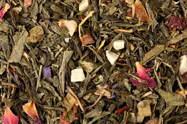 Aromatic green dry tea with fruits and petals, close up — Stock Photo, Image