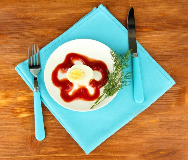 Vařené vejce s kečupem na dřevěné pozadí — Stock fotografie