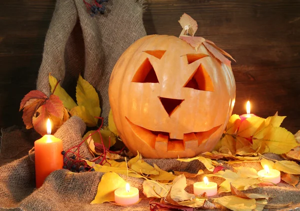 Zucca di Halloween e foglie autunnali, su sfondo di legno — Foto Stock