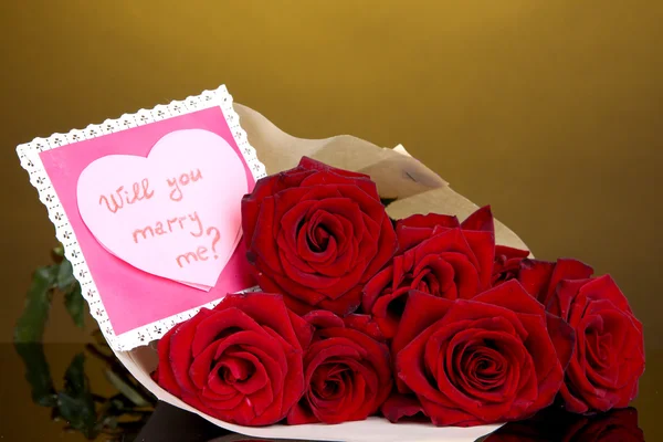 Schöner Strauß roter Rosen mit Valentin auf gelbem Hintergrund — Stockfoto