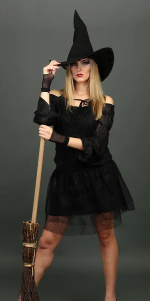 Halloween witch with broom on gray background — Stock Photo, Image