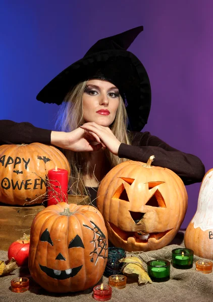 Halloween witch with pumpkins on color background — Stock Photo, Image