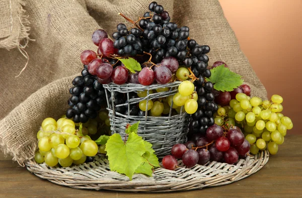 Assortimento di uve dolci mature in cesto, su fondo marrone — Foto Stock
