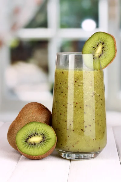 Copo de suco de quivi fresco na mesa de madeira, no fundo da janela — Fotografia de Stock