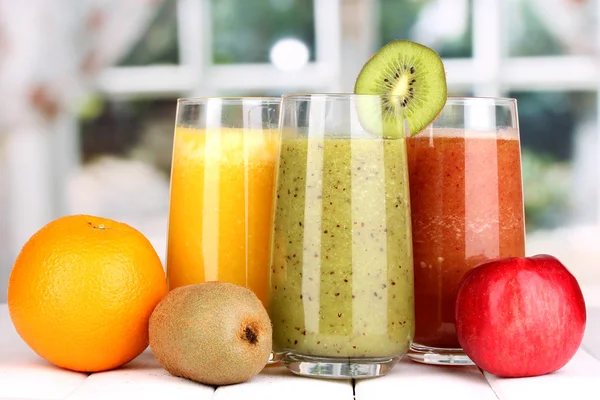 Sucos de frutas frescas na mesa de madeira, no fundo da janela — Fotografia de Stock