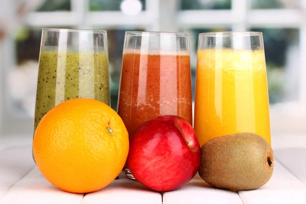 Fresh fruit juices on wooden table, on window background — Stock Photo, Image