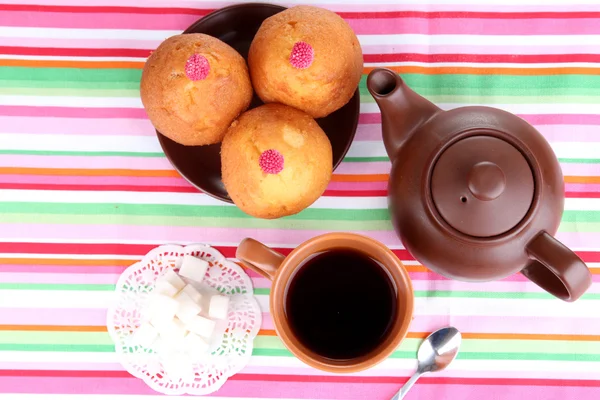 Top view of cup of tea and teapot on colorful tablecloths — Stock Photo, Image