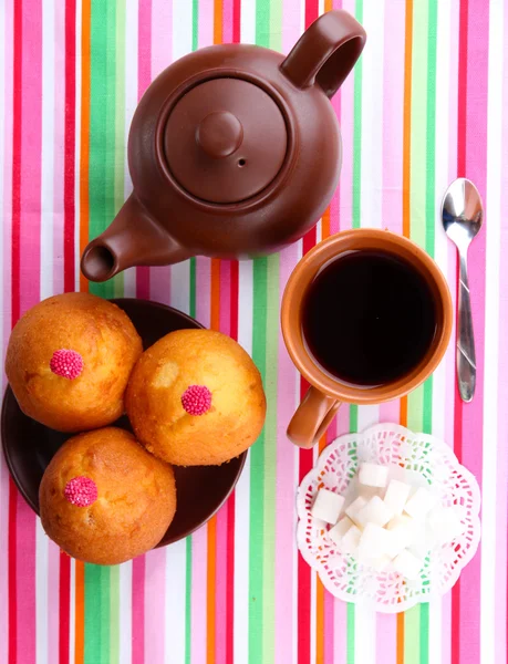 Top view of cup of tea and teapot on colorful tablecloths — Stock Photo, Image