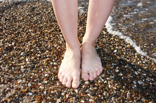 Piernas caminando sobre piedras de playa primer plano — Foto de Stock