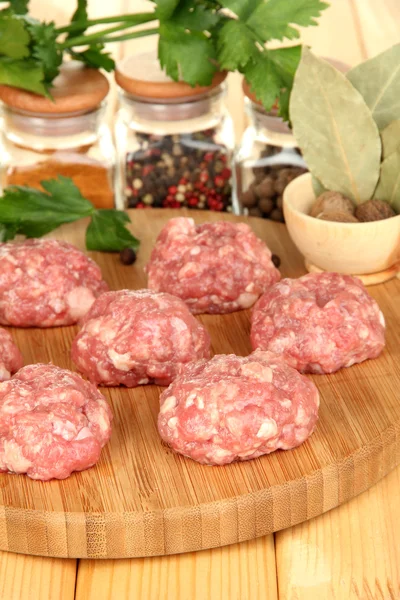 RAW köttbullar med kryddor på träbord — Stockfoto