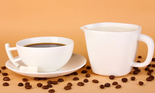 Šálek silné kávy a sladké smetany na béžové pozadí — Stock fotografie