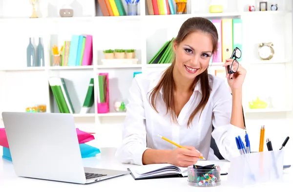 Young pretty business woman with notebook in office — Stock Photo, Image