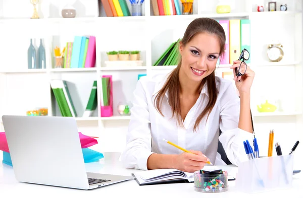 Young pretty business woman with notebook in office Royalty Free Stock Images