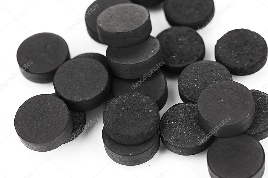 Activated carbon in tablets isolated on white — Stock Photo © belchonock 14316407