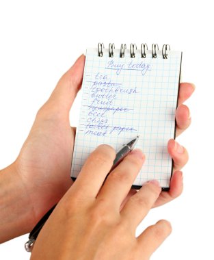 Kadının elinde alışveriş listesi olan bir defter var.