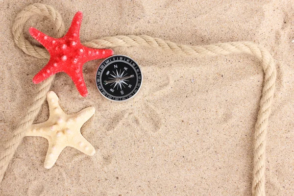 Stelle marine con kompass e corda sulla sabbia — Foto Stock