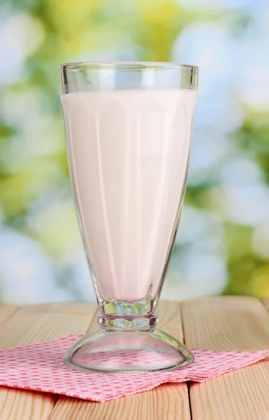 Vanilla milk shake on wooden table on bright background — Stok fotoğraf