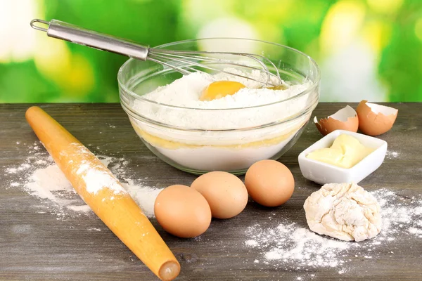 Ägg, mjöl och smör närbild på träbord på naturliga bakgrund — Stockfoto