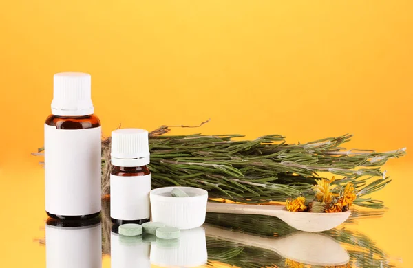 Flaschen mit Medikamenten und Kräutern auf orangefarbenem Hintergrund. Konzept der Homöopathie — Stockfoto