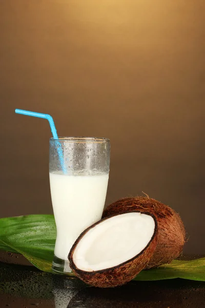 Vaso de leche de coco y coco sobre fondo marrón de cerca —  Fotos de Stock