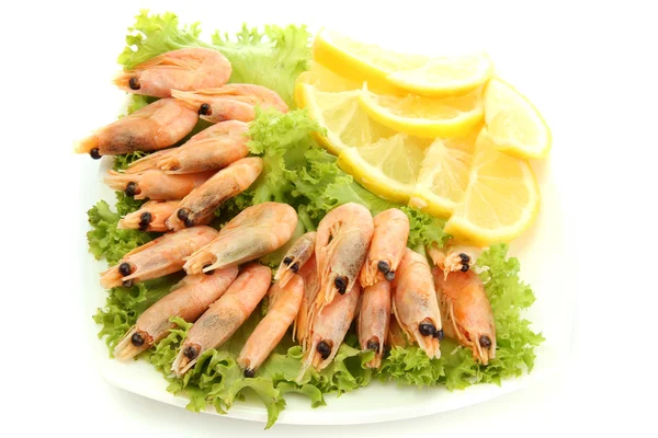 Crevettes bouillies avec des feuilles de citron et de laitue sur l'assiette, isolées sur blanc — Photo