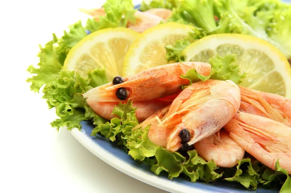 Camarones hervidos con hojas de limón y lechuga en plato, aislados en blanco — Foto de Stock