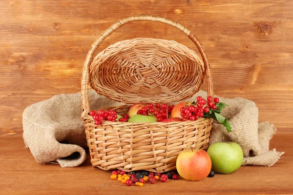 Cosecha de bayas y frutas en una canasta sobre fondo de madera primer plano —  Fotos de Stock