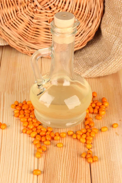 Decanter with sea buckthorn oil on wooden background close-up — 图库照片