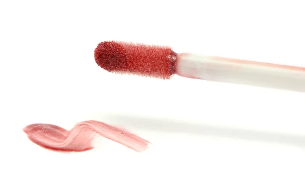 Beautiful lip gloss smear with brush, isolated on white — Stock Photo, Image