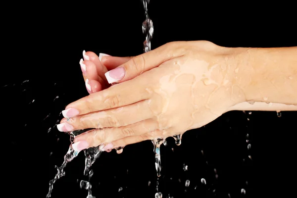 Laver les mains de la femme sur fond noir gros plan — Photo