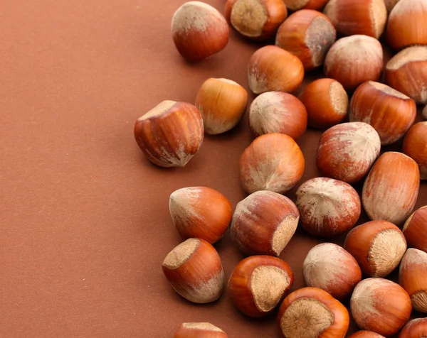 Smakelijke hazelnoten, op bruine achtergrond — Stockfoto