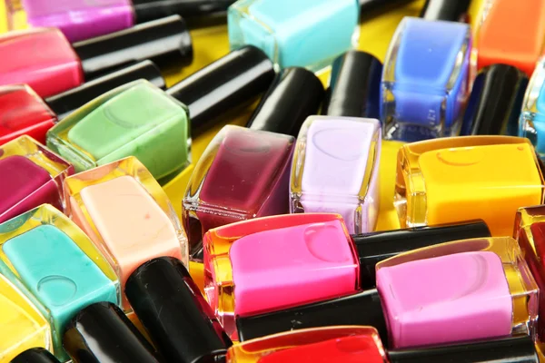 Group of bright nail polishes, on yellow background — Stock Photo, Image