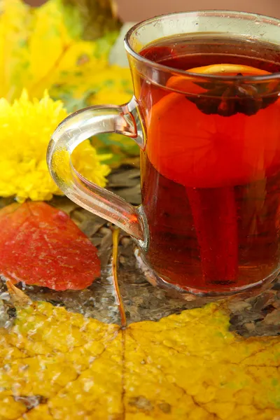 Tasse Heißgetränk und Herbstblätter, Nahaufnahme — Stockfoto