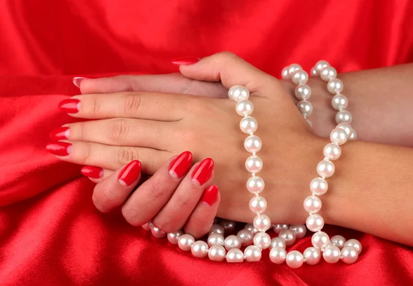 Female hands holding beads on color background — Stock Photo, Image