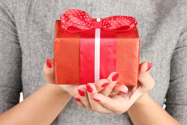Woman holds box with gift on white background close-up — ストック写真