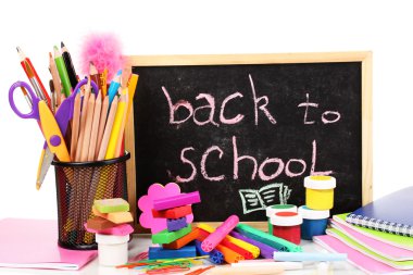 Kelime 'okul Back ile çeşitli okul Masası üzerinde beyaz izole yakın çekim sağlayan küçük okul tebeşir yazılmış'