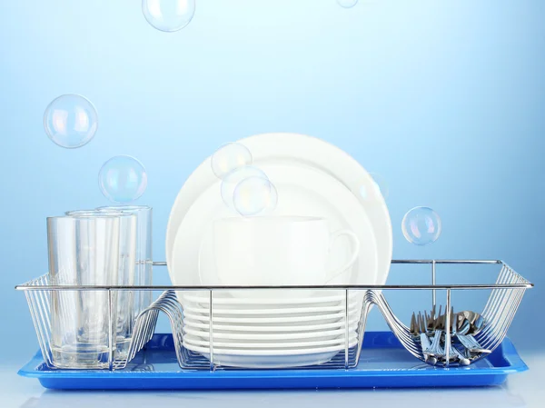 Clean dishes on stand on blue background — Stock Photo, Image