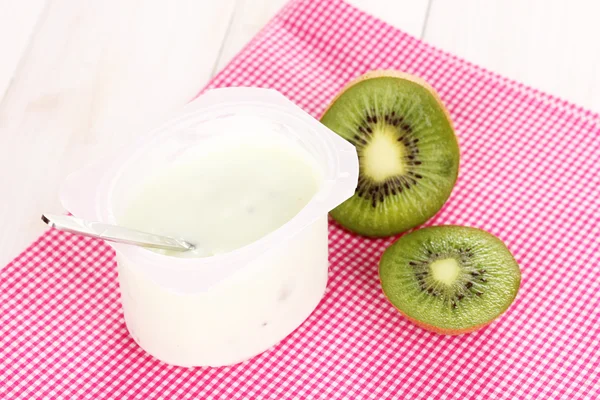 Yogurt con kiwi en servilleta sobre fondo de madera —  Fotos de Stock