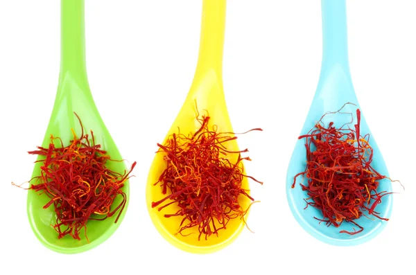 Stigmas of saffron in multicolored spoons on white background close-up — Stock Photo, Image