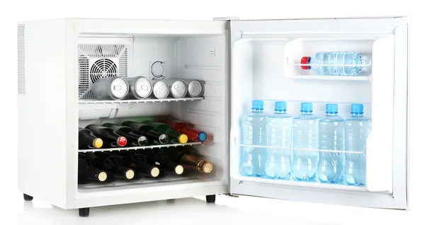 Kulkas mini penuh botol minuman beralkohol dan air yang terisolasi di atas putih — Stok Foto