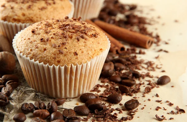 Bolos de muffin saborosos com chocolate, especiarias e sementes de café, em fundo bege — Fotografia de Stock