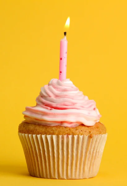 Smakelijke verjaardag cupcake met kaars, op gele achtergrond — Stockfoto