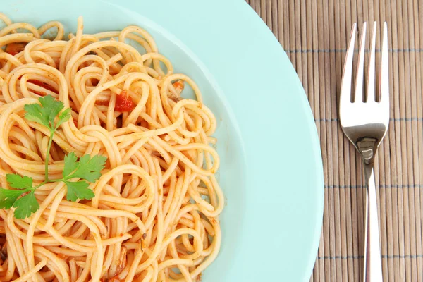 Italian spaghetti in plate on bamboo mat close-up — Stock Photo, Image