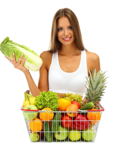 Hermosa joven con frutas y verduras en la cesta de la compra, aislado en blanco — Foto de Stock
