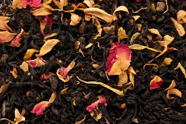 Aromatic black dry tea with fruits and petals, close up — Stock Photo, Image