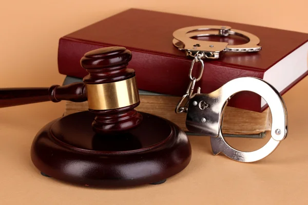 Gavel, handcuffs and book on law on beige background — Stock Photo, Image