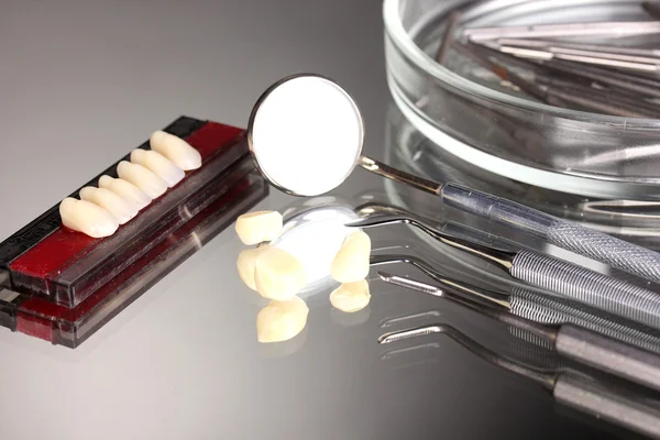 Instellen voor tandheelkundige tools met gebit op grijze achtergrond — Stockfoto