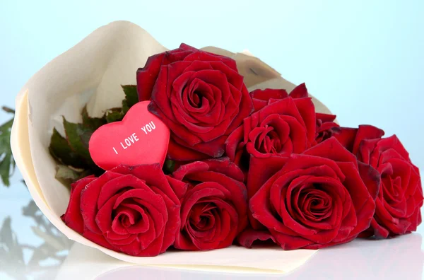 Bellissimo bouquet di rose rosse con San Valentino su sfondo blu — Foto Stock