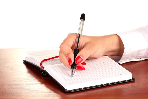 Χέρι εισέλθετε σημειωματάριου στο ξύλινο τραπέζι που απομονώνονται σε λευκό — Φωτογραφία Αρχείου